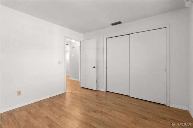 unfurnished bedroom featuring light wood-type flooring and a closet