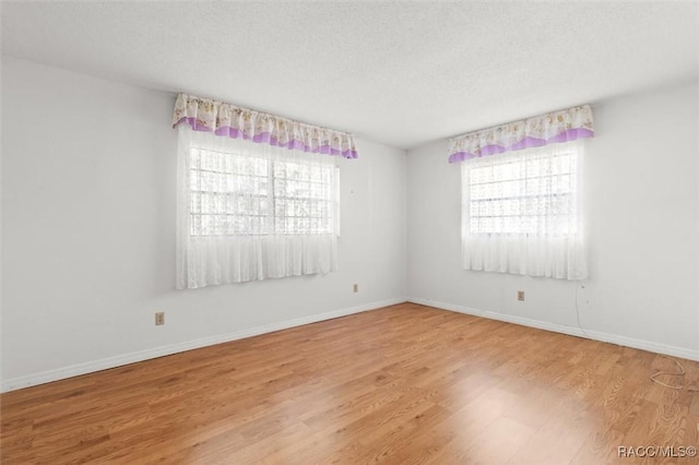 spare room featuring a textured ceiling and light wood-type flooring