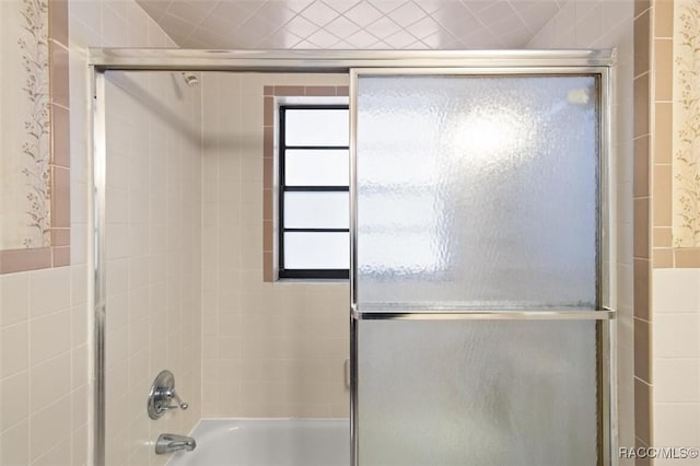 bathroom with shower / bath combination with glass door