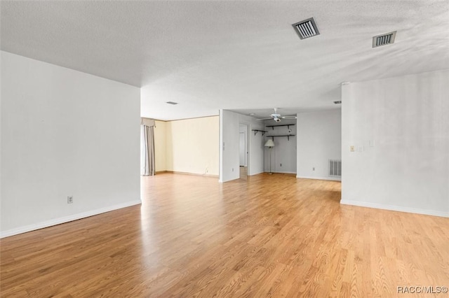 unfurnished living room with ceiling fan, light hardwood / wood-style flooring, and a textured ceiling