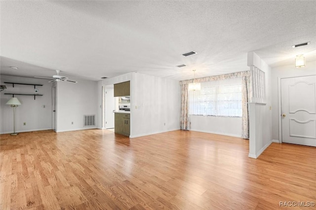 unfurnished living room with ceiling fan, a textured ceiling, and light wood-type flooring