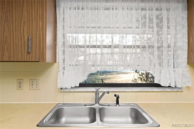 interior details featuring sink and tasteful backsplash