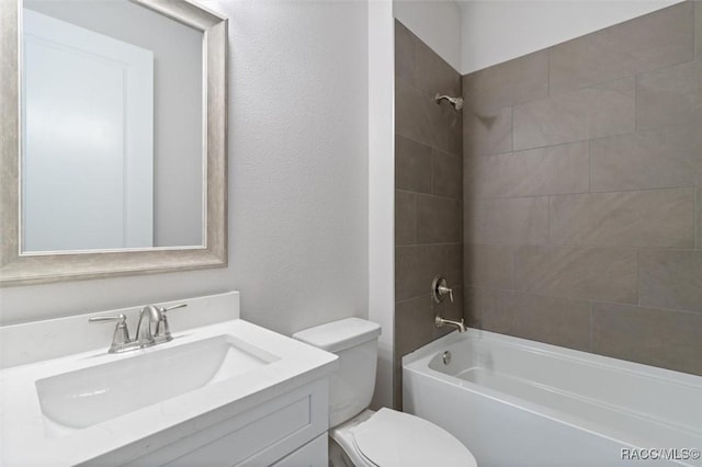 full bathroom with tiled shower / bath combo, toilet, and vanity