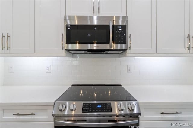 kitchen with appliances with stainless steel finishes, decorative backsplash, and white cabinets