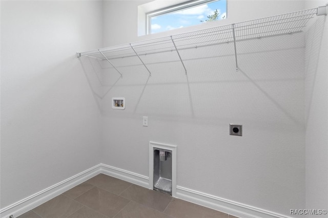 laundry room featuring hookup for a washing machine, dark tile patterned flooring, and electric dryer hookup