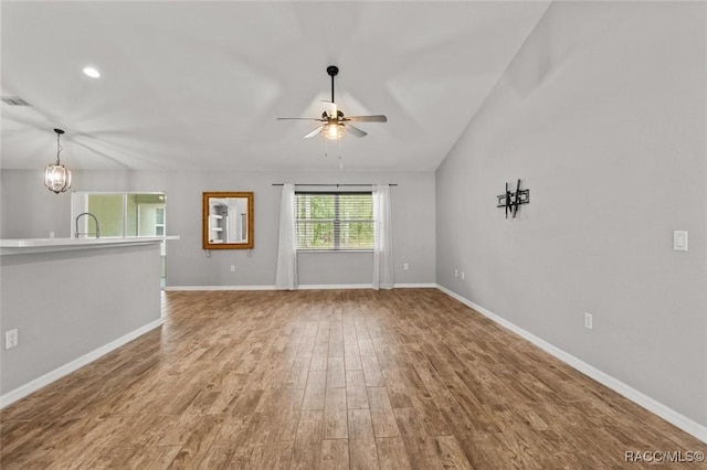 17 Eugenia Ct, Homosassa, FL 34446 - unfurnished living room featuring a sink, baseboards, wood finished floors, and ceiling fan with notable chandelier