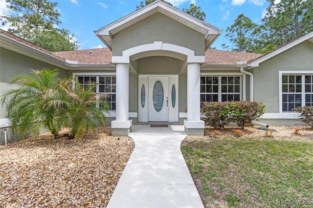 17 Eugenia Ct, Homosassa, FL 34446 - entrance to property featuring roof with shingles and stucco siding