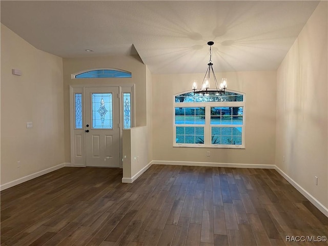 entrance foyer featuring dark hardwood / wood-style flooring and an inviting chandelier