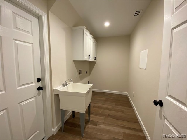 washroom with hookup for an electric dryer, cabinets, dark wood-type flooring, and hookup for a washing machine