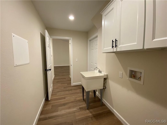 laundry room with cabinets, washer hookup, and dark hardwood / wood-style flooring