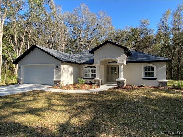 ranch-style house featuring a front yard and a garage