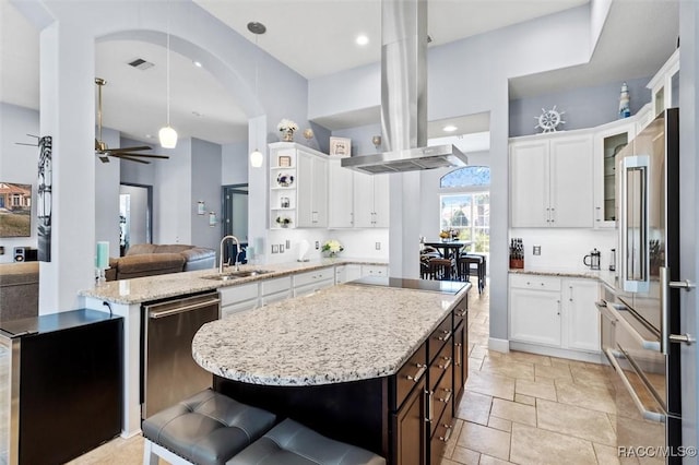 kitchen with sink, white cabinets, hanging light fixtures, a center island, and stainless steel appliances