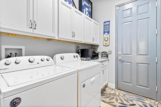 washroom featuring cabinets and washer and clothes dryer