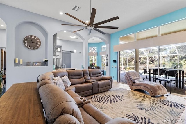 living room featuring ceiling fan and a high ceiling