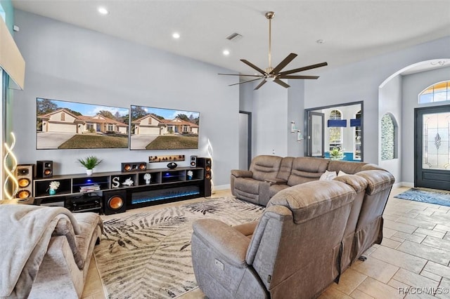 living room featuring a towering ceiling and ceiling fan