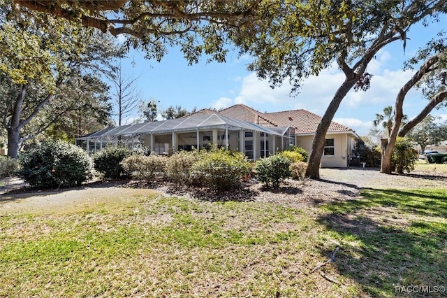 back of property with a lanai and a yard