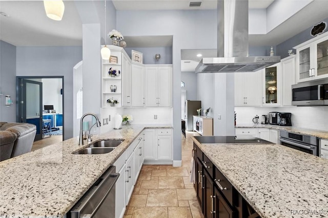 kitchen featuring appliances with stainless steel finishes, island range hood, pendant lighting, sink, and light stone countertops