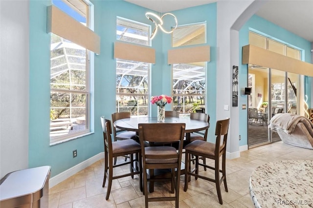 dining space featuring plenty of natural light and a towering ceiling