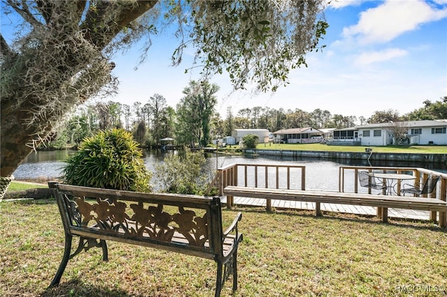 view of dock with a water view and a lawn