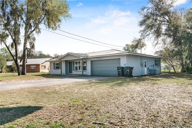 single story home with an attached garage, driveway, metal roof, and a front yard