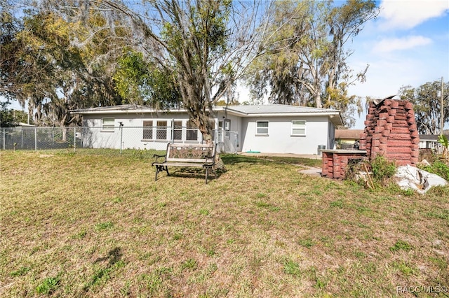 back of property with a yard and fence