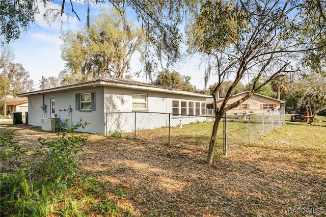 exterior space featuring fence, a lawn, and stucco siding