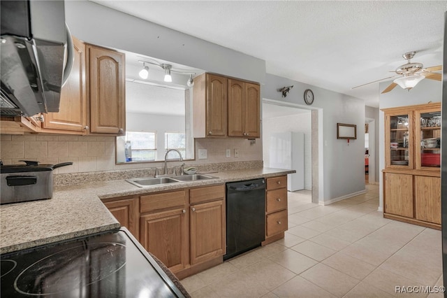 kitchen featuring light tile patterned floors, tasteful backsplash, light countertops, a sink, and black appliances