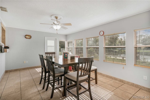 dining room featuring a textured ceiling, light tile patterned flooring, and visible vents