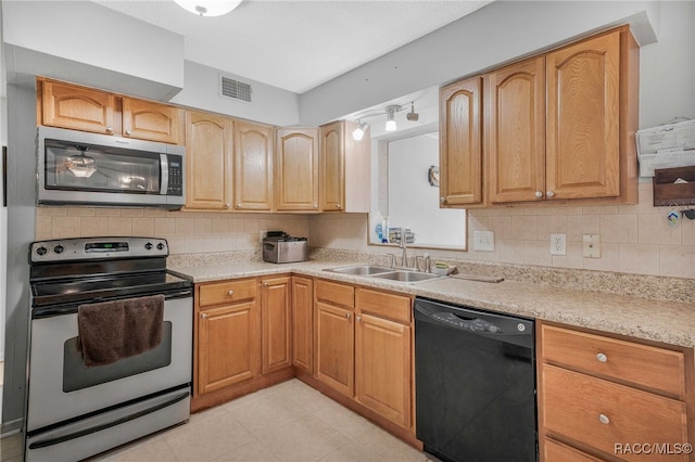 kitchen featuring stainless steel appliances, visible vents, a sink, and backsplash