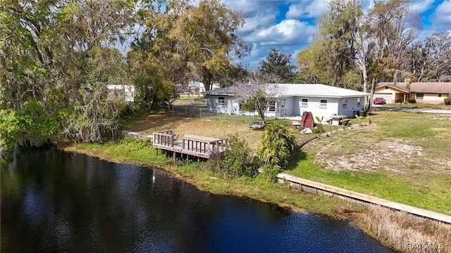 rear view of house featuring a yard and a deck with water view