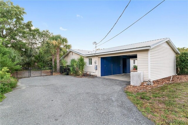 2310 N Watersedge Dr, Crystal River, FL 34429 - view of side of home with asphalt driveway, a gate, and a metal roof