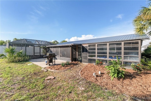 2310 N Watersedge Dr, Crystal River, FL 34429 - rear view of property with a lanai, a metal roof, a patio, and a sunroom