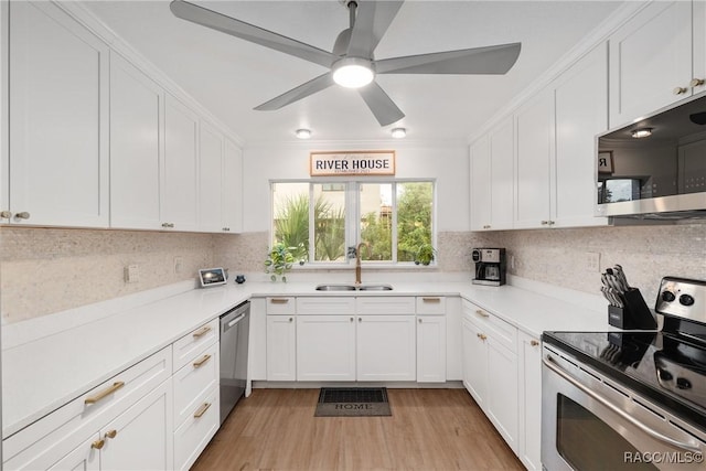 2310 N Watersedge Dr, Crystal River, FL 34429 - kitchen with stainless steel appliances, white cabinetry, decorative backsplash, a ceiling fan, and light wood-type flooring