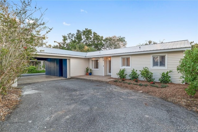 2310 N Watersedge Dr, Crystal River, FL 34429 - ranch-style home with asphalt driveway, a metal roof, and an attached carport