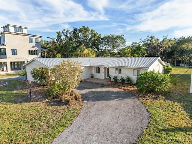 2310 N Watersedge Dr, Crystal River, FL 34429 - view of front facade with driveway, a metal roof, and a front yard