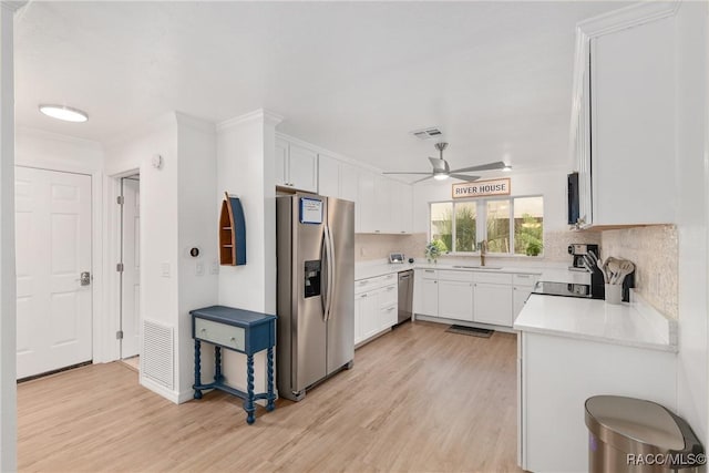 2310 N Watersedge Dr, Crystal River, FL 34429 - kitchen featuring appliances with stainless steel finishes, light wood-style floors, backsplash, and crown molding