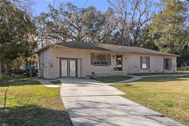 ranch-style house featuring stucco siding, a front lawn, and fence