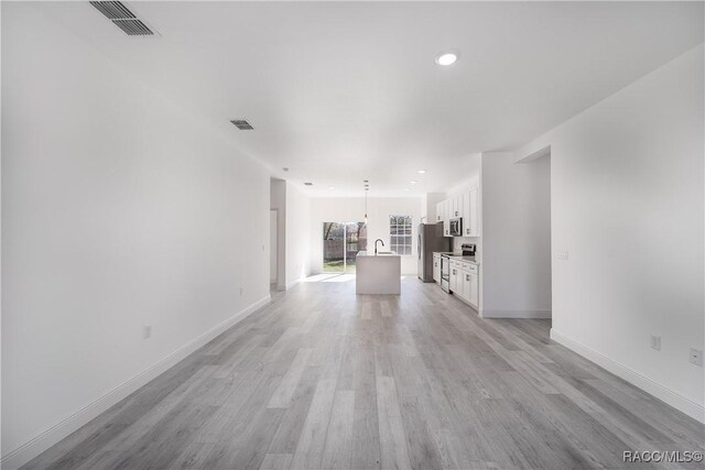 8589 N Sumter Ter, Dunnellon, FL 34433 - unfurnished living room featuring light wood finished floors and recessed lighting