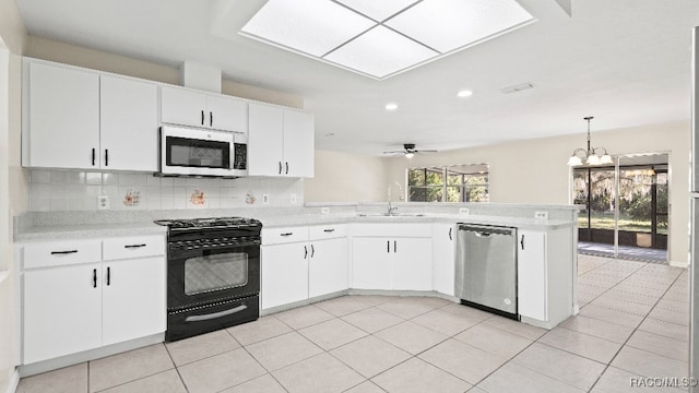 kitchen with white cabinetry, sink, kitchen peninsula, ceiling fan with notable chandelier, and appliances with stainless steel finishes