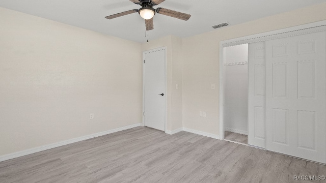 unfurnished bedroom with ceiling fan, a closet, and light wood-type flooring