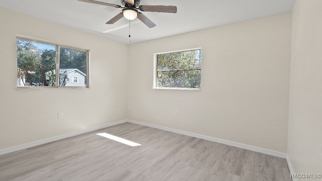 empty room featuring ceiling fan, a healthy amount of sunlight, and light hardwood / wood-style floors