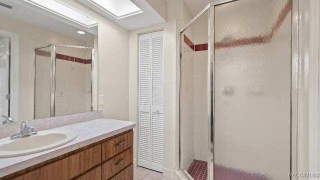 bathroom with tile patterned flooring, vanity, and a shower with door