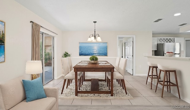 dining space with a chandelier and light tile patterned floors