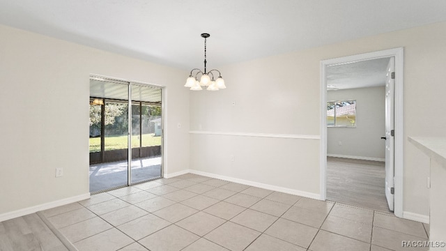 tiled spare room with a wealth of natural light, a textured ceiling, and a notable chandelier