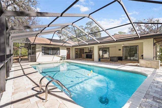 view of pool featuring ceiling fan, glass enclosure, and a patio