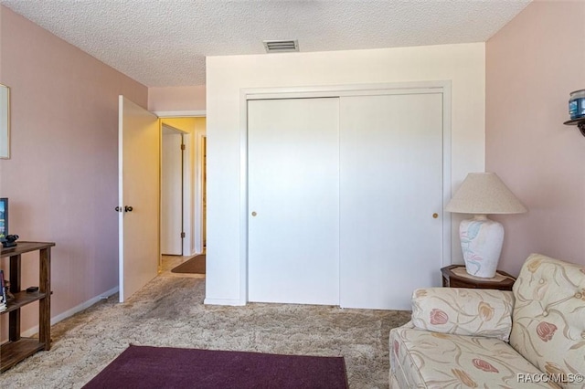 sitting room with a textured ceiling and light carpet