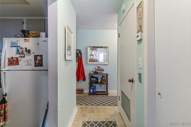 hall with a textured ceiling