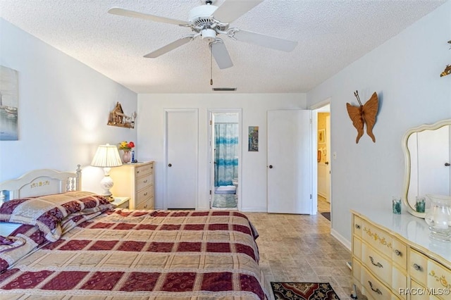 bedroom with ceiling fan, connected bathroom, and a textured ceiling