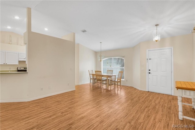 interior space featuring light hardwood / wood-style flooring, a chandelier, and vaulted ceiling