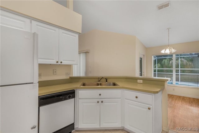 kitchen featuring decorative light fixtures, kitchen peninsula, sink, white appliances, and white cabinetry